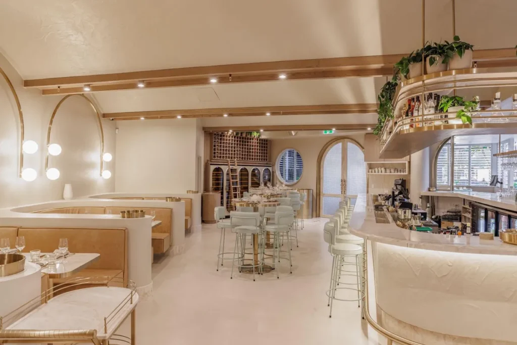 Your Guide to Cement Render: Everything You Need to Know natural coloured restaurant with booth seating and high bar tables next to a bar