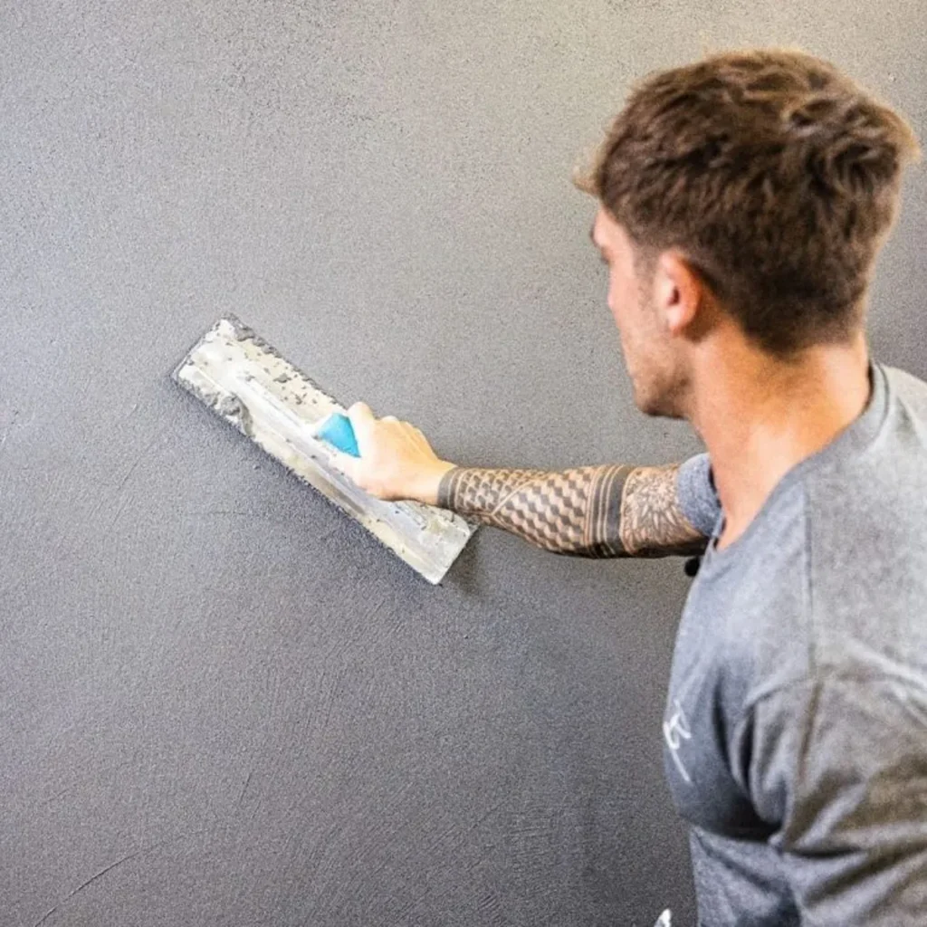 Your Guide to Cement Render: Everything You Need to Know man applying grey render to a wall.