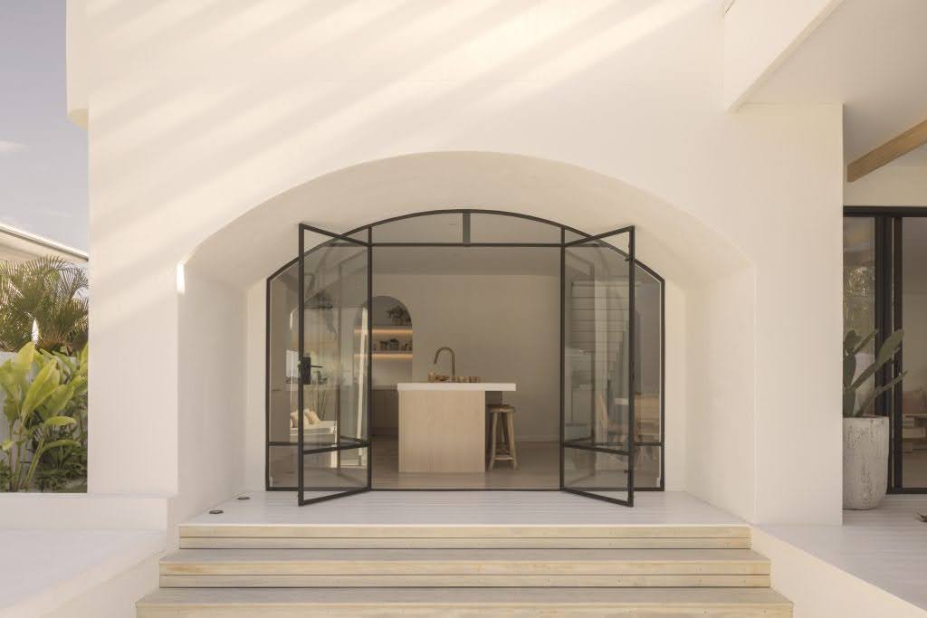 Your Guide to Cement Render: Everything You Need to Know white entry way with glass doors leading into the kitchen
