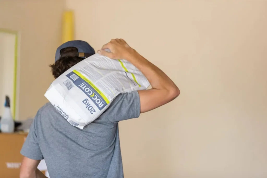 Sustainability Man holding a bad of render mix over his shoulder