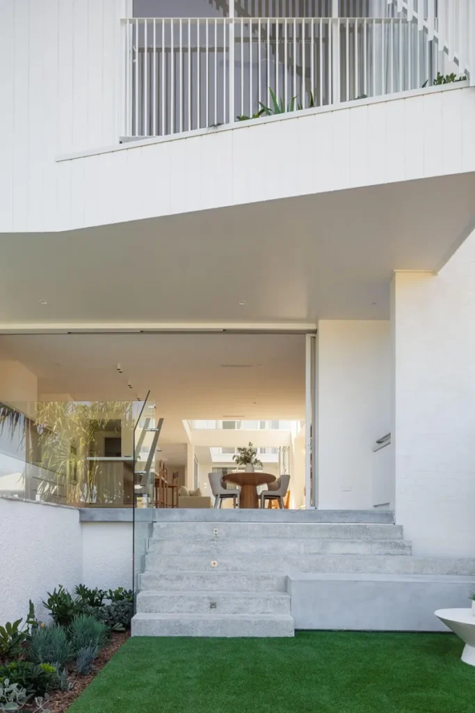 Sustainability Grey and white rendered backyard with lawn looking into dining room.