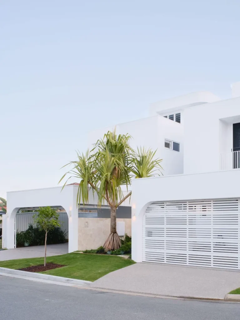 Sustainability Two storey modern white coastal house with a large palm tree