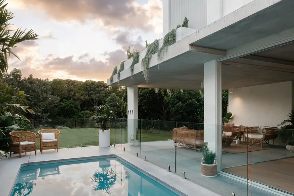 Sustainability House backyard with pool and outdoor seating looking out to grass and trees