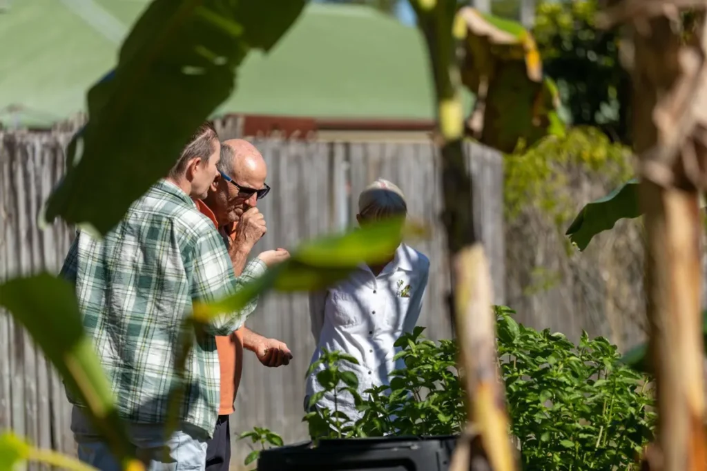 Sustainability Three people in a garden looking at plants