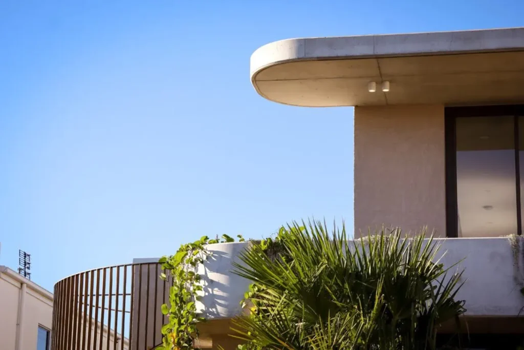 What Are the Best Brands for Textured Wall Paint in Australia? Corner of an architectural house with greenery and the sky in the background