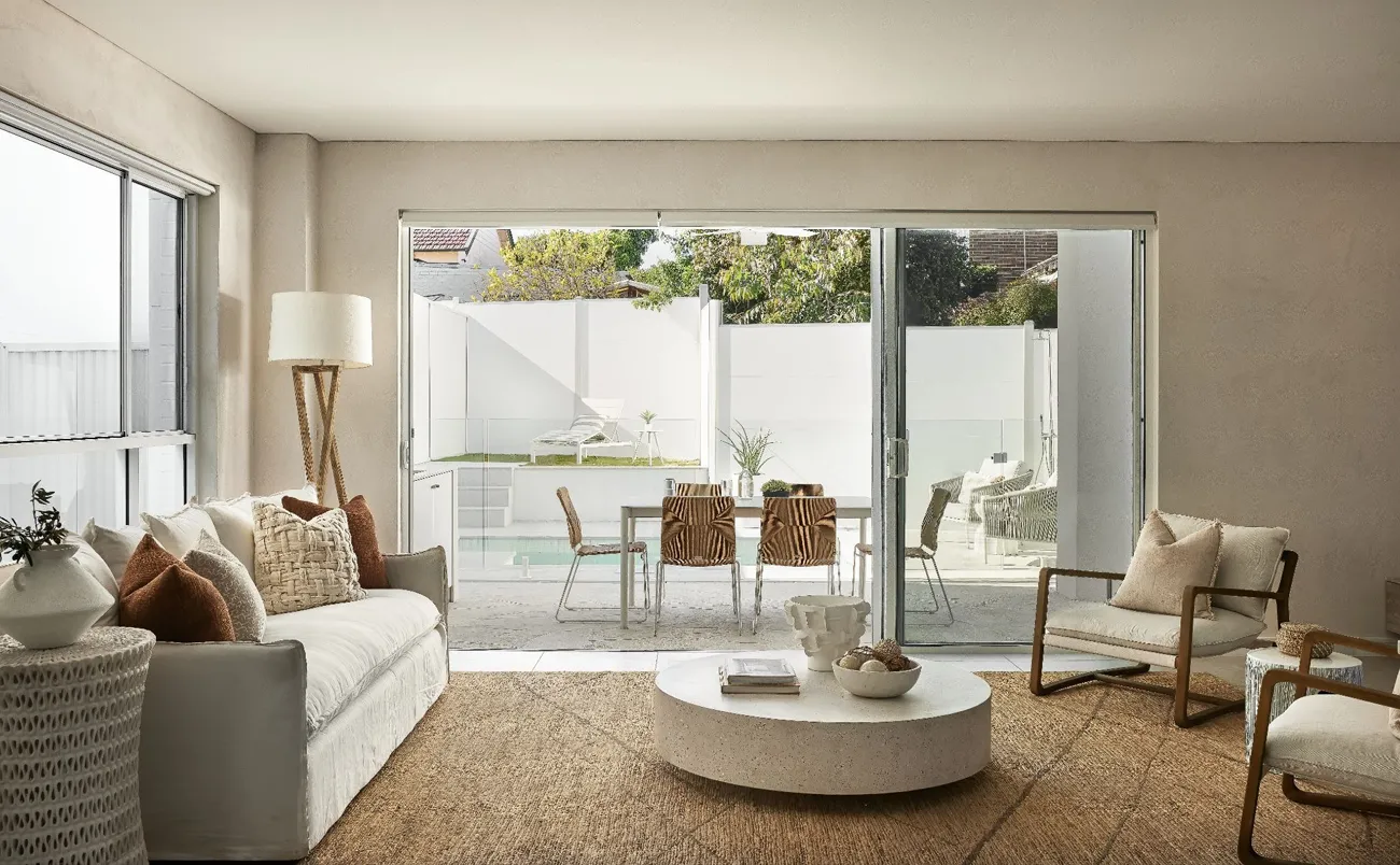 What Are the Best Brands for Textured Wall Paint in Australia? Landscape photo of modern coastal home with doors open leading out to a pool and entertaining area.